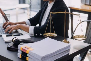 abogado trabajando en despacho con documentos y balanza